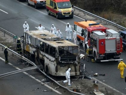 Officials work at the site of a bus accident, in which at least 46 people were killed, on a highway near the village of Bosnek, south of Sofia, on November 23, 2021. - 46 people, including a dozen minors, were killed after a bus caught fire south of the Bulgarian …