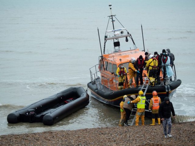 Migrants are helped ashore from an RNLI (Royal National Lifeboat Institution) lifeboat at a beach in Dungeness, southeast England, on November 24, 2021 after being rescued while crossing the English Channel. - The past three years have seen a significant rise in attempted Channel crossings by migrants, despite warnings of …