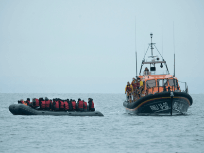 Migrants are helped by RNLI (Royal National Lifeboat Institution) lifeboat before being taken to a beach in Dungeness, on the south-east coast of England, on November 24, 2021, after crossing the English Channel. - The past three years have seen a significant rise in attempted Channel crossings by migrants, despite …
