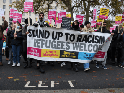 LONDON, ENGLAND - NOVEMBER 27: Demonstrators carry a banner during the Refugees welcome: Emergency Solidarity Protest on November 27, 2021 in London, England. Protesters from various organisations including Care4CAlais, Jewish Socialist Group, National Education Union, Muslim Association of Briain and Stop The War Coalition hold a demonstration outside Downing Street …