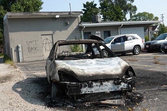 KENOSHA, WISCONSIN - AUGUST 26: A car is burned in the Car Source used car lot where a person was reported to have been shot by a vigilante during a third night of unrest on August 26, 2020 in Kenosha, Wisconsin. Two people were reported dead and another wounded during the incident, as the shooting spread from the lot into the nearby street. Rioting as well as clashes between police and protesters began Sunday night after a police officer shot Jacob Blake seven times in the back in front of his three children. (File Photo by Scott Olson/Getty Images)