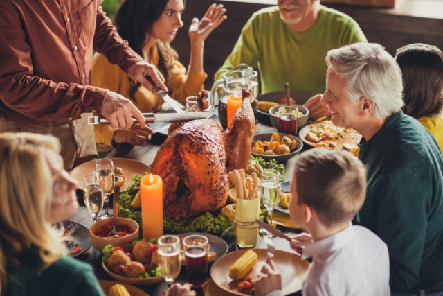 Cropped photo of family meeting, served table thanks giving dinner two knives slicing stuf