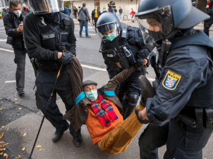 FRANKFURT AM MAIN, GERMANY - NOVEMBER 14: Police officers carry an old man who tried to bl