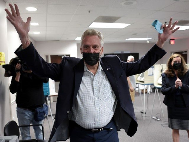Former Virginia Gov. Terry McAuliffe, Democratic gubernatorial candidate for Virginia for a second term, accompanied by his wife Dorothy (R), celebrates after casting his ballot during early voting at the Fairfax County Government Center on October 13, 2021 in Fairfax, Virginia. McAuliffe will face off against Republican nominee Glenn Youngkin …