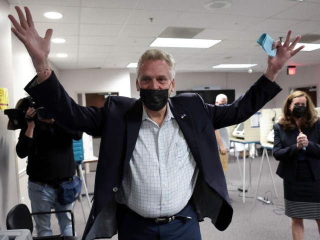 Former Virginia Gov. Terry McAuliffe, Democratic gubernatorial candidate for Virginia for a second term, accompanied by his wife Dorothy (R), celebrates after casting his ballot during early voting at the Fairfax County Government Center on October 13, 2021 in Fairfax, Virginia. McAuliffe will face off against Republican nominee Glenn Youngkin in the Virginia gubernatorial election on November 2. (Photo by Win McNamee/Getty Images)