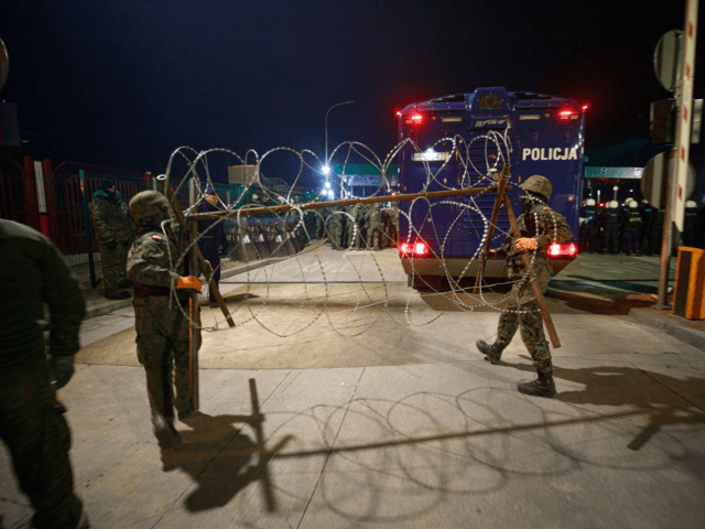 UNSPECIFIED, POLAND- NOVEMBER 15: In this handout photo provided by the Territorial Defence Forces of Poland's Ministry of National Defence, members of the Territorial Defence Force secure the fence at the closed Kuznica border crossing where thousands of migrants has been relocated by Belarusian soldiers on November 15, 2021 in …