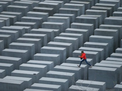 BERLIN, GERMANY - OCTOBER 28: A boy hops from one to another of the 2,711 stellae at the Memorial to the Murdered Jews of Europe, also called the Holocaust Memorial, on October 28, 2013 in Berlin, Germany. The monument, located in the city center, was designed by American architect Peter …