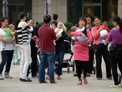 A group of women hold babies gathering at a residential area in Beijing on September 16, 2014. China began to implement the loosening of its controversial one-child policy on January 17, when a province announced it has made it legal for couples to have two children if one parent is …