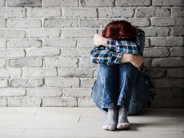 Depressed young crying woman - victim of domestic violence and abuse. Domestic violence