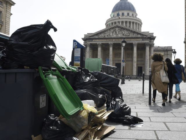 Pedestrians walk past rubbish bins on the pavement near the Pantheon (C) in Paris on June 10, 2016. The piles of uncollected household rubbish accumulating in parts of the capital, giving off a foul smell as the temperatures rise, was hardly the image of France that the Euro 2016 organisers …