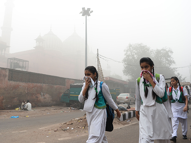 Indian schoolchildren cover their faces as they walk to school amid heavy smog in New Delhi on November 8, 2017. Delhi shut all primary schools on November 8 as pollution levels hit nearly 30 times the World Health Organization safe level, prompting doctors in the Indian capital to warn of a public health emergency. Dense grey smog shrouded the roads of the world's most polluted capital, where many pedestrians and bikers wore masks or covered their mouths with handkerchiefs and scarves. / AFP PHOTO / SAJJAD HUSSAIN (Photo credit should read SAJJAD HUSSAIN/AFP via Getty Images)