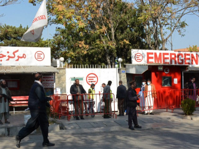 Afghan medical staff members (C) stand at the entrance of a hospital as they wait to recei