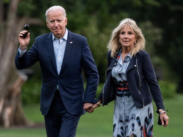US President Joe Biden and First Lady Jill Biden walk on the South Lawn upon returning to
