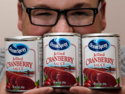 Nick Mackara poses for a photograph with cans of Ocean Spray cranberry sauce Wednesday, No