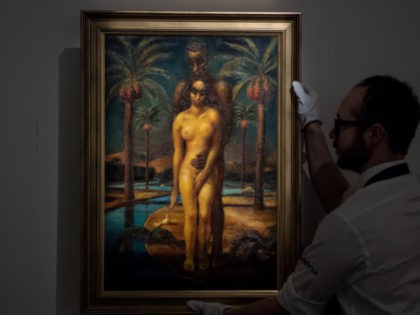LONDON, ENGLAND - APRIL 20: A Sotheby's art handler poses with 'Adam and Eve' by Mahmoud S