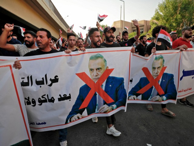 Iraqi demonstrators lift banners against Prime Minister Mustafa Al-Kadhimi during a protest rejecting last month's election result, near an entrance to the Green Zone in Baghdad on November 5, 2021. - Hundreds of supporters of pro-Iran groups clashed with security forces in Iraq's capital, expressing their fury over last month's election result, AFP journalists and a security source said. (Photo by Ahmad AL-RUBAYE / AFP) (Photo by AHMAD AL-RUBAYE/AFP via Getty Images)