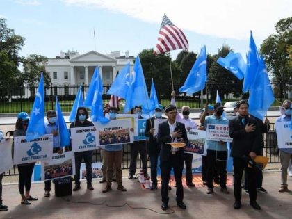 Uyghurs of the East Turkistan National Awakening Movement (ETNAM) listen to their national anthem as they hold a rally to protest the 71st anniversary of the People's Republic of China in front of the White House in Washington, DC, on October 1, 2020. (Nicholas Kamm/AFP via Getty Images)