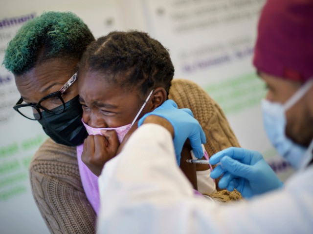 Markeata West, left, holds her daughter, Justice, 6, as she receives the Pfizer COVID-19 vaccine for children ages 5-11 from Dr. Eugenio Fernandez at Asthenis Pharmacy in Providence, R.I., Friday, Nov. 5, 2021. (AP Photo/David Goldman)