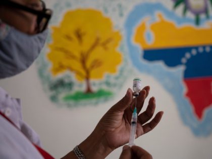 A Venezuelan doctor prepares a syringe with a dose of the COVID-19 vaccine developed by China's Sinopharm at a vaccination center in the Miguel Antonio Caro high school in Catia, Venezuela, on March 8, 2021. - A batch of 500,000 doses of COVID-19 vaccines from the Chinese pharmaceutical company Sinopharm …
