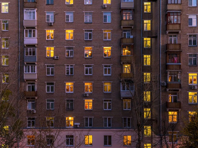Illuminated windows of dwelling apartment complex- stock photo