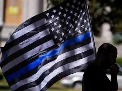 FILE - In this Aug. 30, 2020 file photo, an unidentified man participates in a Blue Lives Matter rally in Kenosha, Wis. University of Wisconsin-Madison’s police chief has banned officers from using “Thin Blue Line” imagery while on duty. The move by Chief Kristen Roman follows criticism on social media …