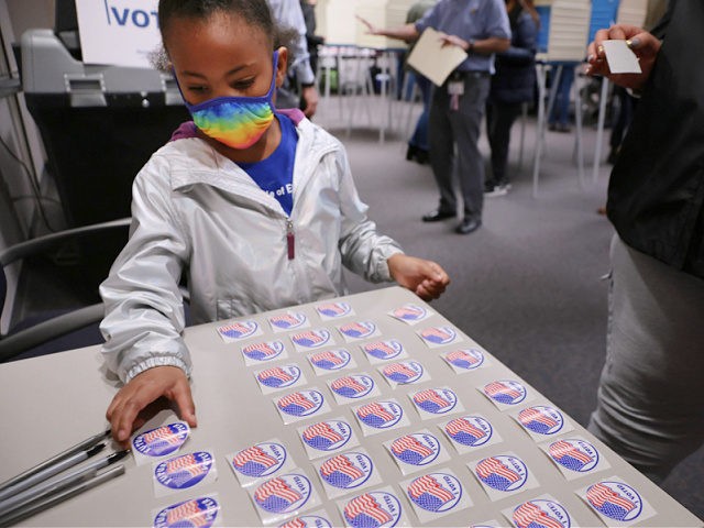 FAIRFAX, VIRGINIA - NOVEMBER 02: Five-year-old Savannah Angel Harris picks up a sticker reading "Future Voter" while accompanying her mother to vote at the Fairfax County Government Center on November 02, 2021 in Fairfax, Virginia. Virginians are voting in a gubernatorial race that pits businessman, Republican candidate Glenn Youngkin against …