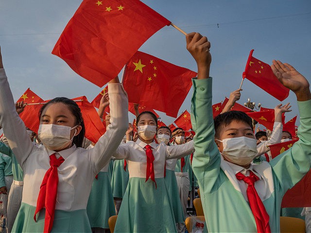 BEIJING, CHINA - JULY 01: Chinese students wave party and national flags at a ceremony marking the 100th anniversary of the Communist Party at Tiananmen Square on July 1, 2021 in Beijing, China. (Photo by Kevin Frayer/Getty Images)