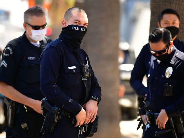 Los Angeles Police Department (LAPD) officers wear facial covering while monitoring an "Open California" rally in downtown Los Angeles, on April 22, 2020. - Over the past week there have been scattered protests in several US states against confinement measures, from New Hampshire, Maryland and Pennsylvania to Texas and California. …