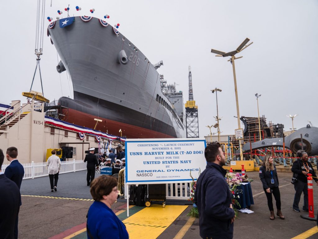 Guests walk past the USNS Harvey Milk at General Dynamics NASSCO shipyard during the ceremonial address in San Diego, California on November 6, 2021. - One of the first openly gay politicians in the United States, who was assassinated four decades ago, will have a ship named after him this weekend, as the US military looks to keep step with modern-day social attitudes. The USNS Harvey Milk honours a former navy diver who served at a time there was a ban on homosexuality in the armed forces, and who was later shot dead in San Francisco, months after winning public office. (Photo by ARIANA DREHSLER / AFP) (Photo by ARIANA DREHSLER/AFP via Getty Images)
