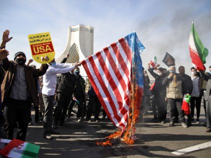 Iranians burn the US flag during a ceremony marking the 42nd anniversary of the 1979 Islamic Revolution, at the Azadi (Freedom) square in Tehran, on February 10, 2021. (Photo by STR / AFP) (Photo by STR/AFP via Getty Images)