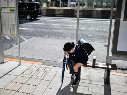 A school pupil waits for the bus at a station in Tokyo's Ginza area on February 2, 2021 as Japan's government is set to approve a month-long extension of its coronavirus state of emergency. (Photo by Charly TRIBALLEAU / AFP) (Photo by CHARLY TRIBALLEAU/AFP via Getty Images)