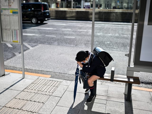 A school pupil waits for the bus at a station in Tokyo's Ginza area on February 2, 2021 as