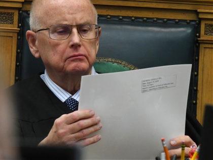 KENOSHA, WISCONSIN - NOVEMBER 09: Circuit court Judge Bruce E. Schroeder examines photographs taken by freelance photographer Nathan DuBruin is of and after unrest in Kenosha, during the Kyle Rittenhouse trial at the Kenosha County Courthouse on November 9, 2021 in Kenosha, Wisconsin. Rittenhouse is accused of shooting three demonstrators, …
