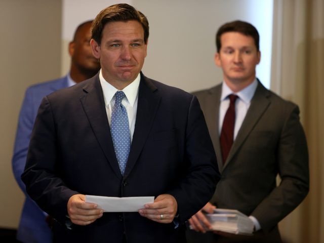 SURFSIDE, FLORIDA - AUGUST 10: Florida Gov. Ron DeSantis waits to present a check to a first responder during an event to give out bonuses to them held at the Grand Beach Hotel Surfside on August 10, 2021 in Surfside, Florida. DeSantis gave out some of the $1,000 checks that …