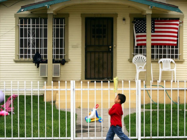 MAYWOOD, CA - MAY 17: An American flag hangs on a single-family home in this Latino neighborhood May 17, 2006 in the Los Angeles-area city of Maywood, California. In November, voters, angered that city police were stopping and seizing hundreds of cars whose unlicensed drivers frequently turned out to be …