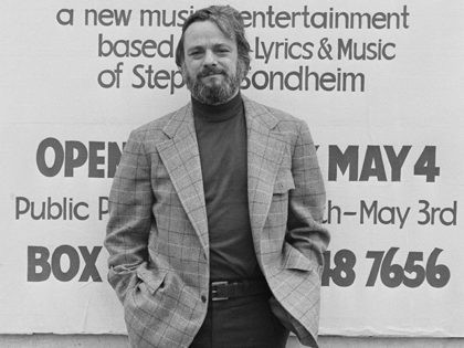 American composer and lyricist Stephen Sondheim poses in front of a poster for 'Side