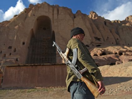 TOPSHOT - In this picture taken on March 3, 2021 a policeman patrols at the site of the Buddhas of Bamiyan statues, which were destroyed by the Taliban in 2001, in Bamiyan province. - Afghanistan's giant Buddhas stood watch over the picturesque Bamiyan valley for centuries, surviving Mongol invasions and …