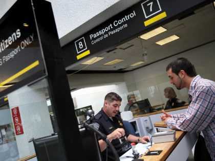 MIAMI - JUNE 22: Fernando Esterlich, a Customs and Border Protection officer, checks passp