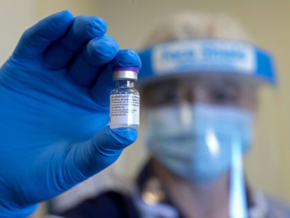 An NHS (National Health Service) worker holds up a vial of the Pfizer-Biontech covid-19 va