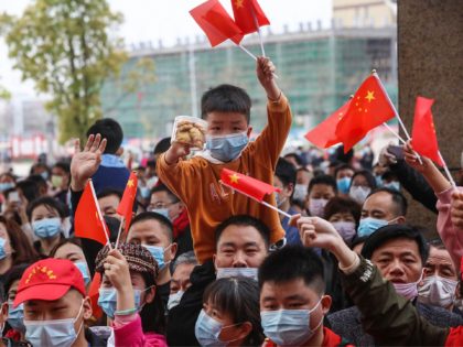 This photo taken on March 23, 2020 shows residents cheering as members of a medical assistance team from Chongqing depart after helping with the COVID-19 coronavirus recovery effort in Yunmeng county, in Xiaogan city in China's central Hubei province. - China announced on March 24 that a lockdown would be …