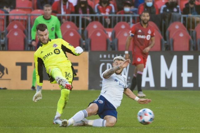 Toronto FC's Quentin Westberg (L) and Paul Arriola of DC United battle for possession in t