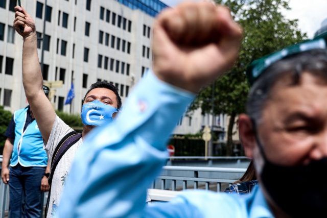 Demonstrators from the Uyghur community protest outside the Belgian parliament as it votes