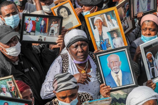 Israelis from the Ethiopian community hold photographs of their relatives during a demonstration demanding the rescue of their relatives left behind amidst the conflict in Ethiopia, outside the Prime Minister's office in Jerusalem