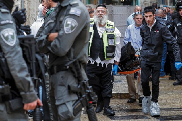 Israeli security forces transport a dead body from the scene of a shooting in the Old City