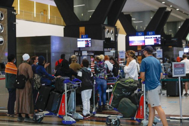 Travellers queue at check-in counters at Johannesburg international airport on Saturday af