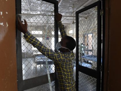 An Indian carpenter fix a wire mesh on a door of an isolation ward for possible Zika virus patients at the Ahmedabad Municipal Corporation run Vadilal Sarabhai (VS) Hospital in Ahmedabad on October 27, 2018. - Gujarat Health Department started taking precautions against Zika virus by major cleanliness drive and …