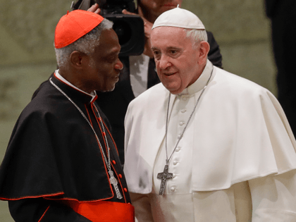 Pope Francis talks with Cardinal Peter Kodwo Appiah Turkson during his weekly general audience, in Paul VI Hall at the Vatican, Wednesday, Jan. 15, 2020. (AP Photo/Alessandra Tarantino)