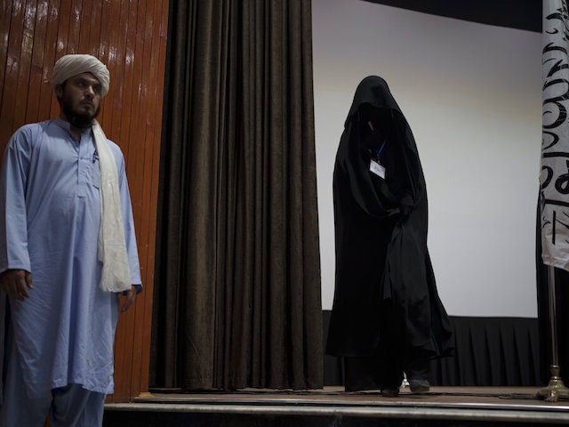 A woman walks down from the stage inside an auditorium at Kabul University's education center during a demonstration in support of the Taliban government in Kabul, Afghanistan, Saturday, Sept. 11, 2021. (AP Photo/Felipe Dana)