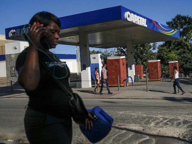 People walk past a closed gas station in Port-au-Prince, Haiti, Thursday, Nov. 11, 2021. T