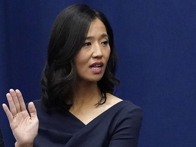 Michelle Wu raises her hand as she is sworn-in as Boston Mayor during a ceremony at Boston